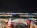展望デッキから撮影された、輝く空港の夜景と大型航空機。