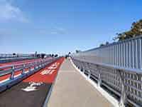 赤と白の舗装が特徴的な、多摩川スカイブリッジの広々とした歩道と自転車道。