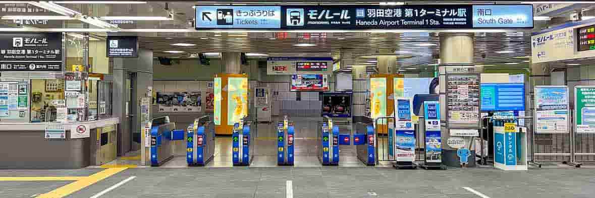駅員が立つブースと案内表示がある、羽田空港第1ターミナル南口のモノレール乗り場。