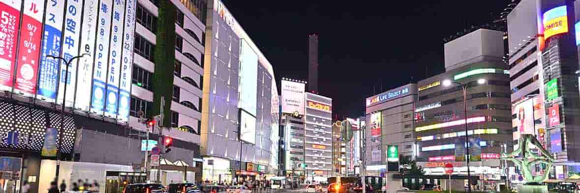 夜の池袋駅前、高層ビルとネオンの輝き。
