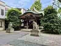 都会の喧騒の中に佇む、池袋大鳥神社の静かな境内と狛犬の像。