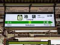 駅のホームに設置された、隣駅も案内している駅名標。