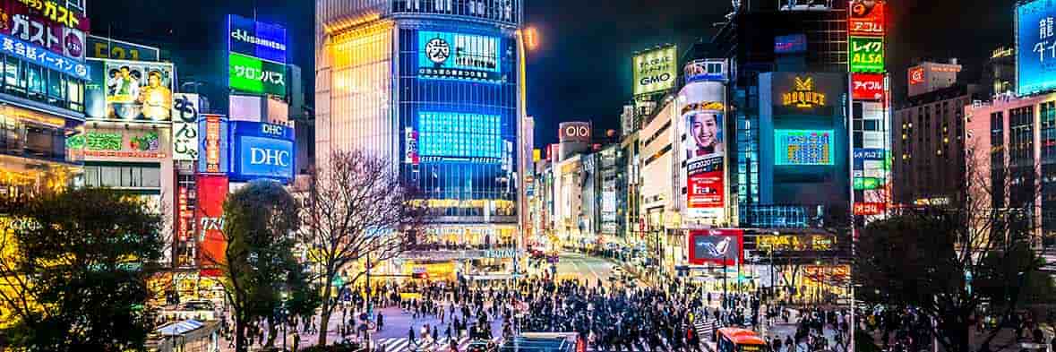 東京渋谷の象徴、スクランブル交差点の夜景。色鮮やかな広告が街を照らす。