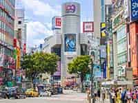 晴れた日の渋谷北西部、109ビルを中心に多くの商業施設が立ち並び、人通りが賑やか。