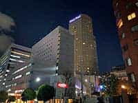 夜の品川プリンスホテル。「Prince Hotel」のロゴが輝き、多くの部屋に明かりが灯っている。