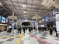 天井の高い駅コンコース、ライトアップされた近代的なビル、そして再開発が進む駅前広場。