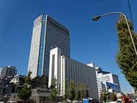 品川駅高輪口に位置する品川プリンスホテルのメインタワー。周辺の緑と青い空のコントラスト。
