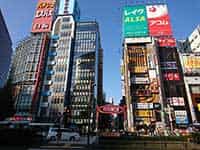 新宿東側の街並み。カラフルなビルボードが目を引く高層ビル群と、通りを行き交う人々。