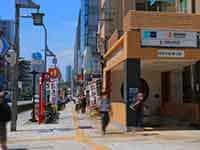 青空の下、東京メトロ稲荷町駅の出入口と、建物が並ぶ清洲橋通り。