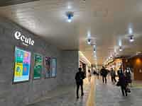 駅ナカ商業施設「エキュート上野」の明るい空間と、ショッピングを楽しむ人々。