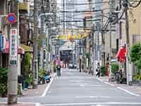 都会の細い通り、看板や電線が特徴的な東上野の街並み。