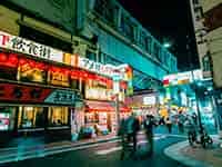 活気ある夜の上野駅周辺、飲食店が並ぶ路地と明るい看板。